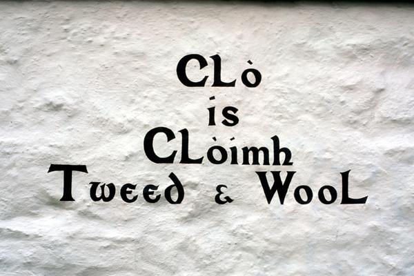 Particolare di testo gaelico Clo is Cloimh dipinto sul muro bianco di un negozio di artigianato a Isle Ornsay, penisola di Sleat, Isola di Skye 