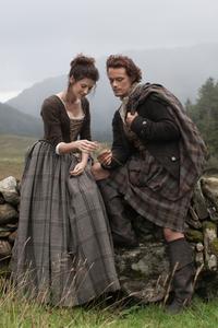 Outlander's Claire en Jamie zittend op een muur © Sony Pictures Television Inc. Alle rechten voorbehouden.